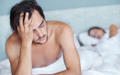 Man looking distraught in bed